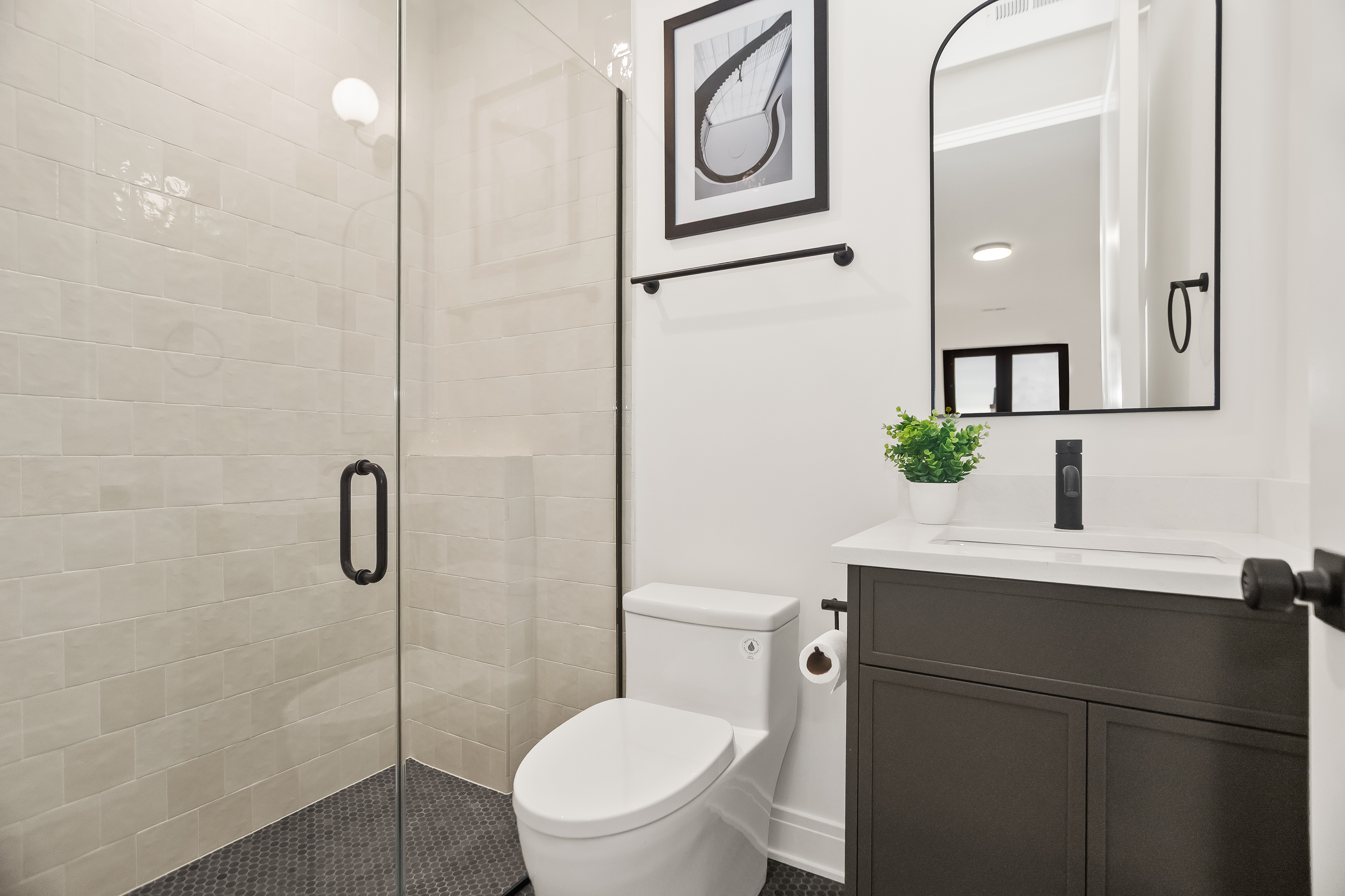 Bathroom with glass shower and dark vanity
