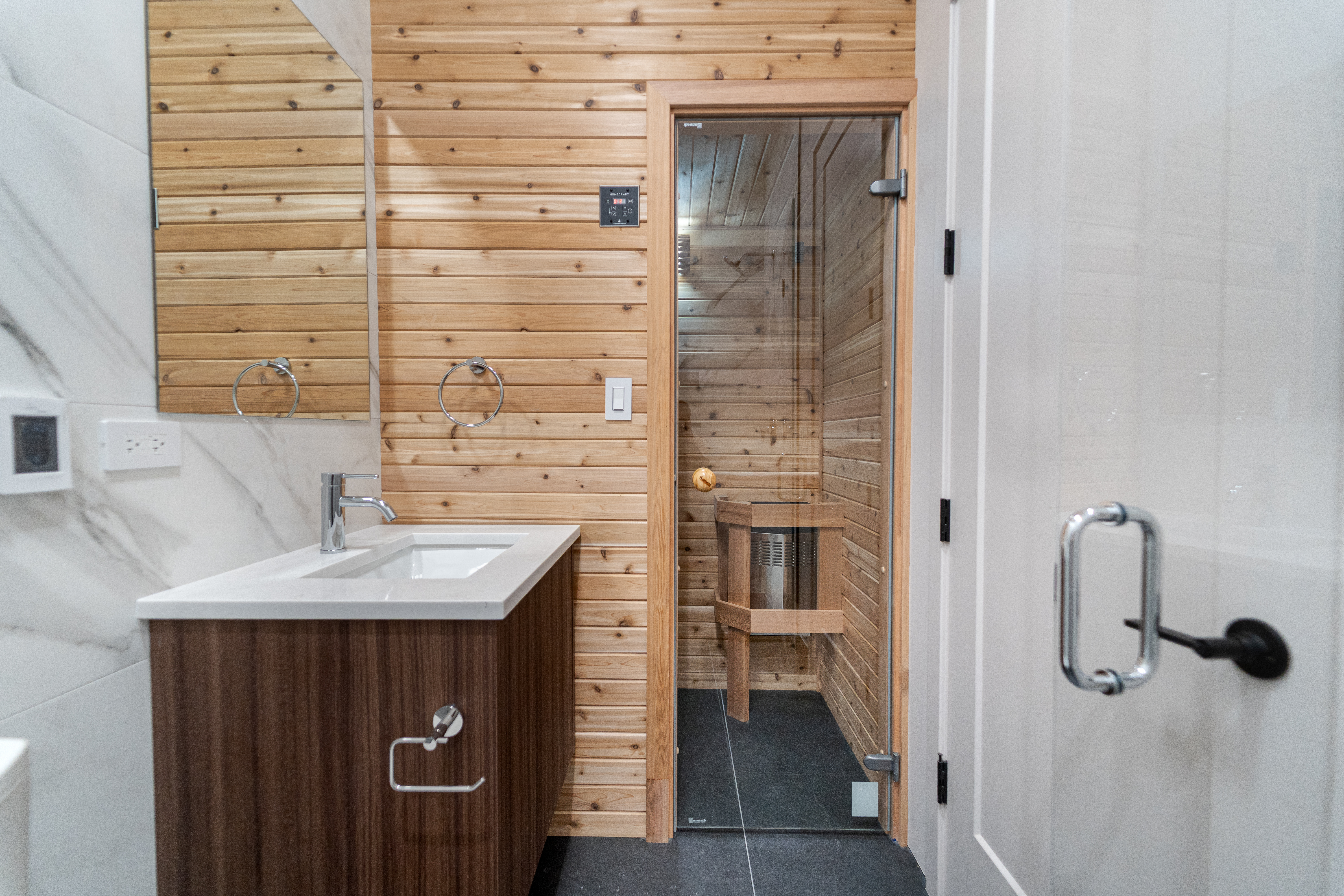 Bathroom with glass shower and cedar sauna