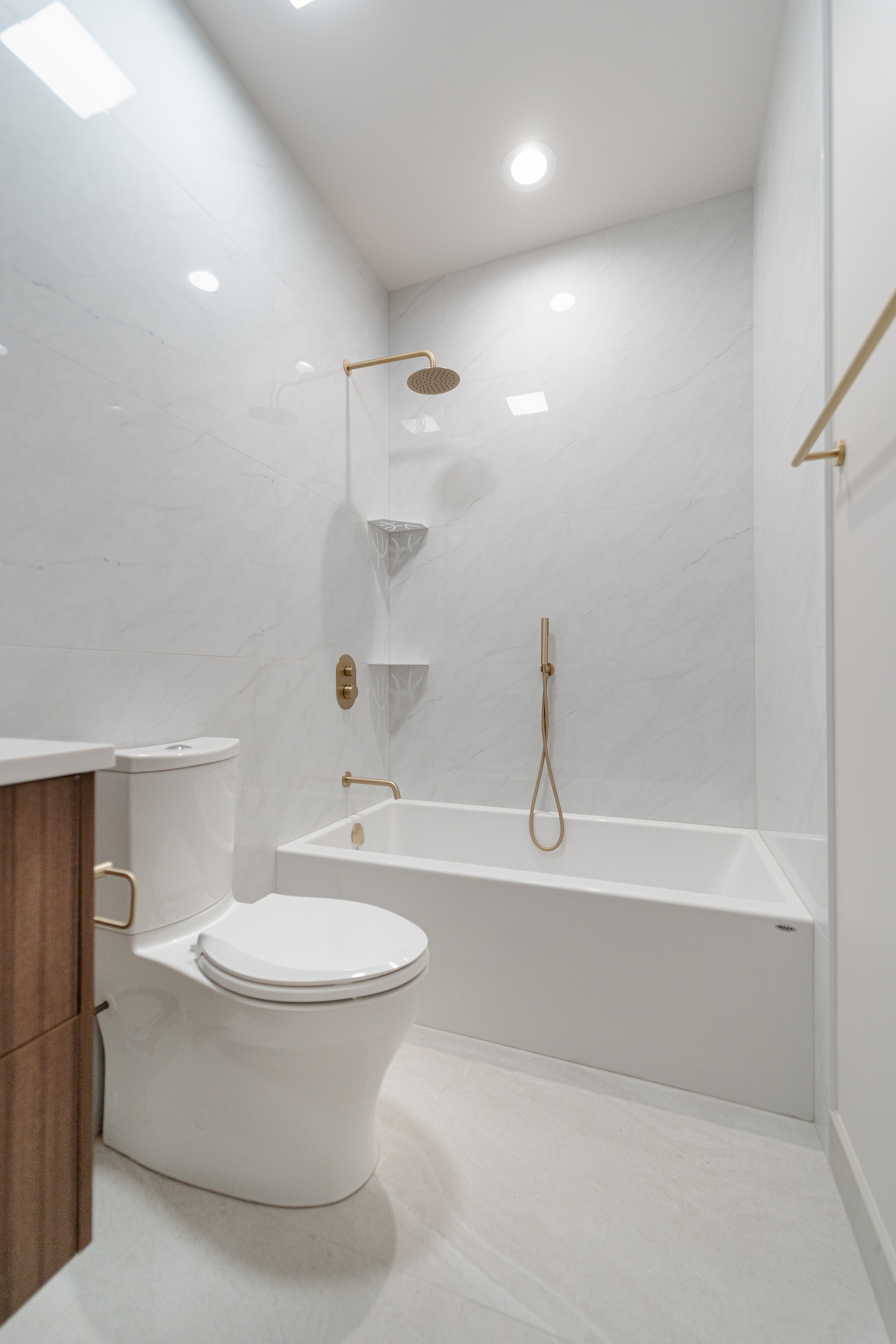 Marble-clad bathroom with bathtub and brass fixtures