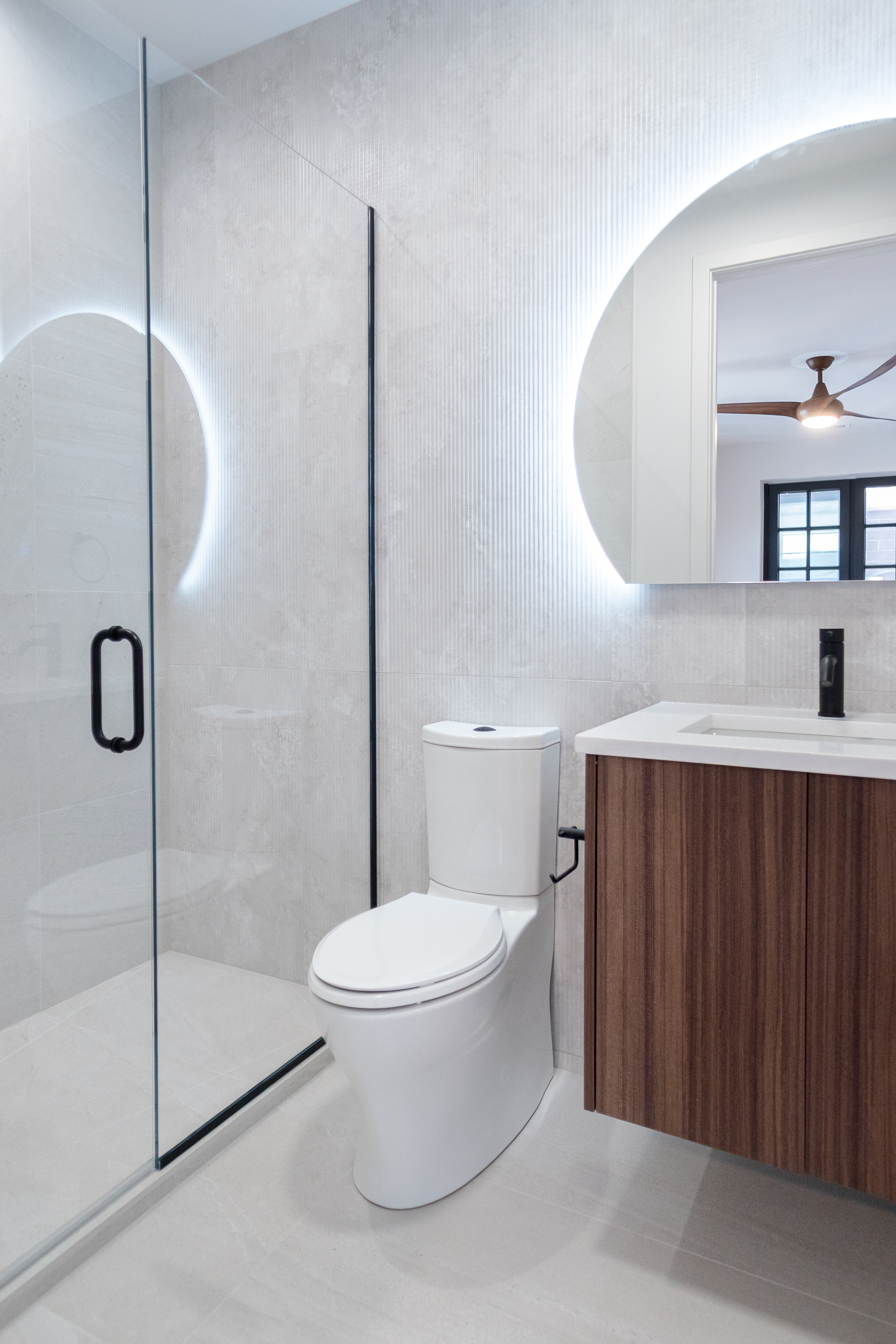 Bathroom with illuminated mirror and glass shower