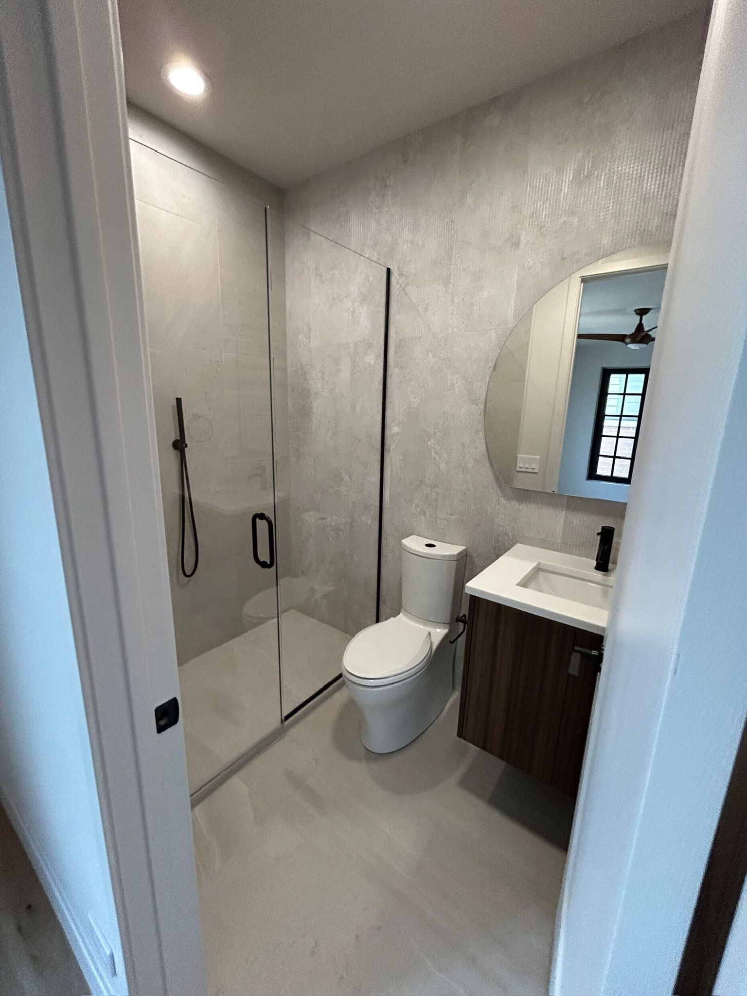 Bathroom with walk-in shower and dark vanity