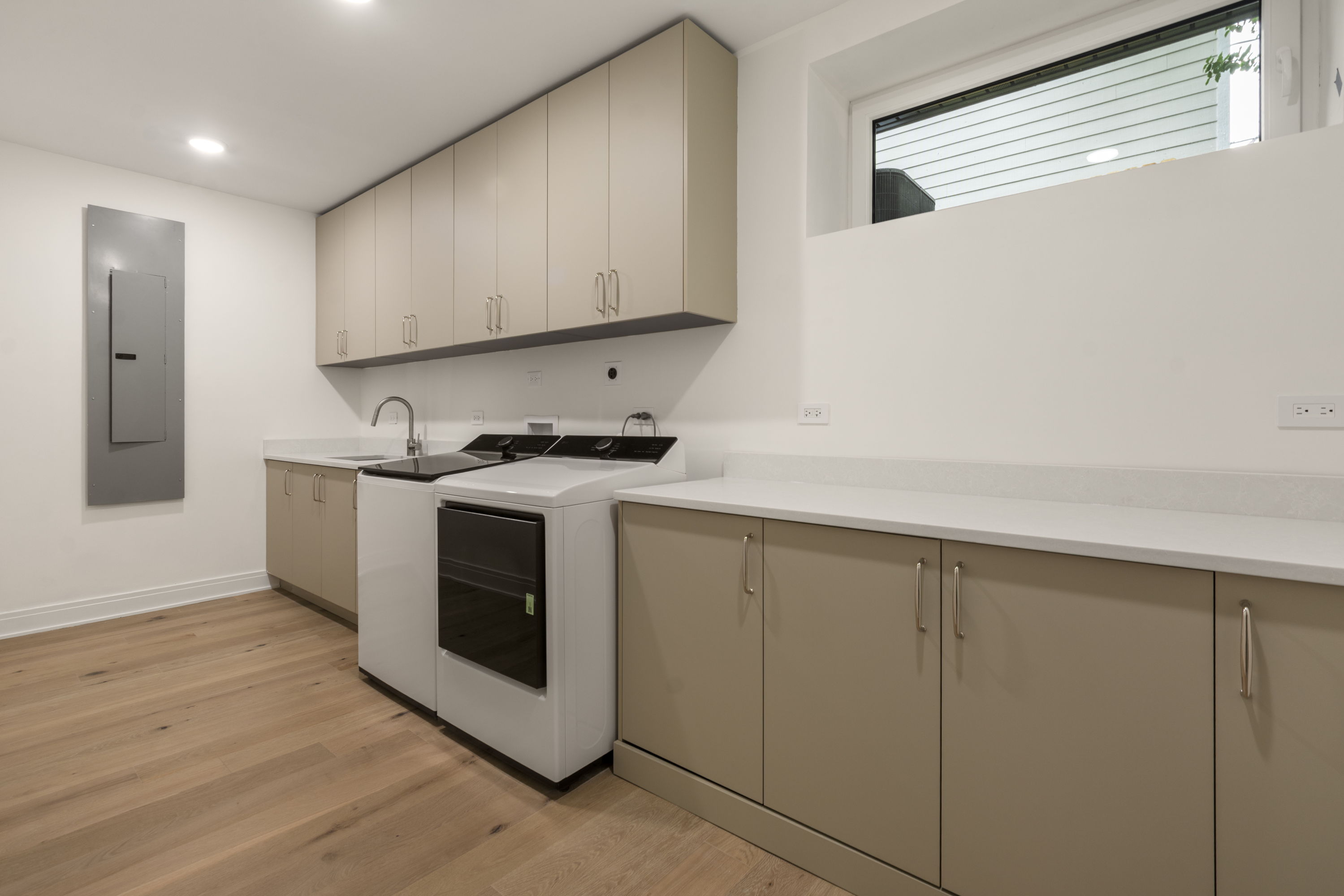 Laundry room with side-by-side washer and dryer, sink, and built-in cabinetry